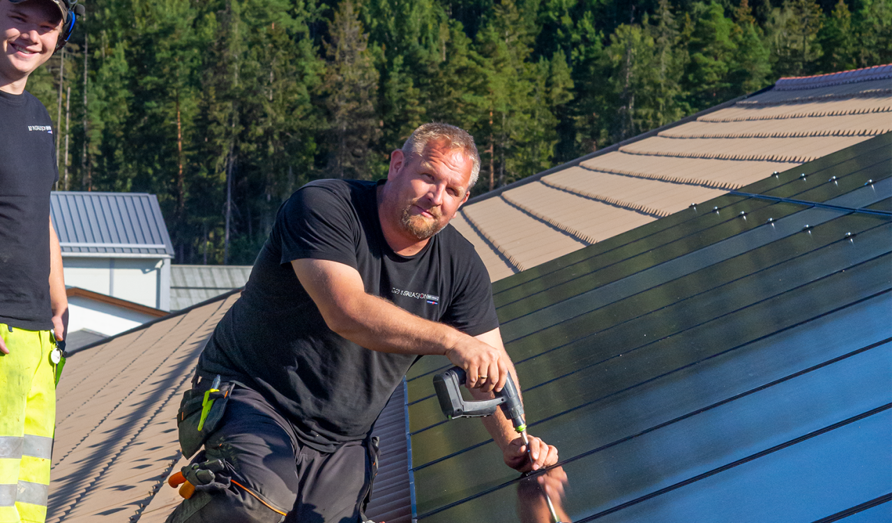 To ansatte fra Bø Installasjon installerer et solcelleanlegg.