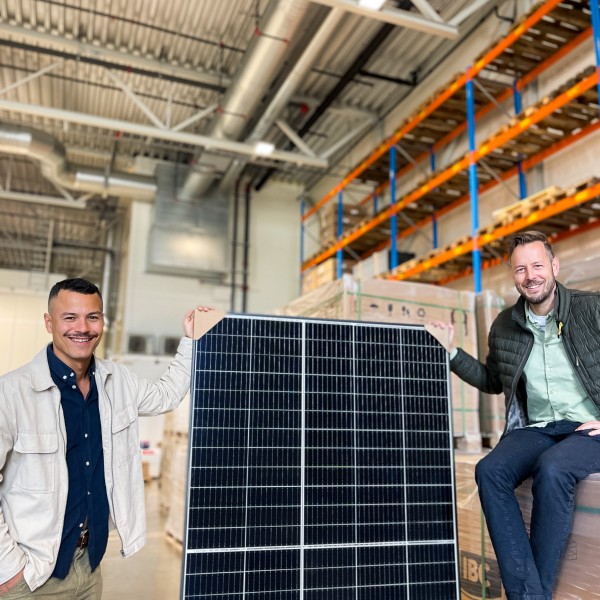 Fagspesialistene Benjamin og Magnus poserer ved siden av en solcelle på BA sentrallageret på Langhus.