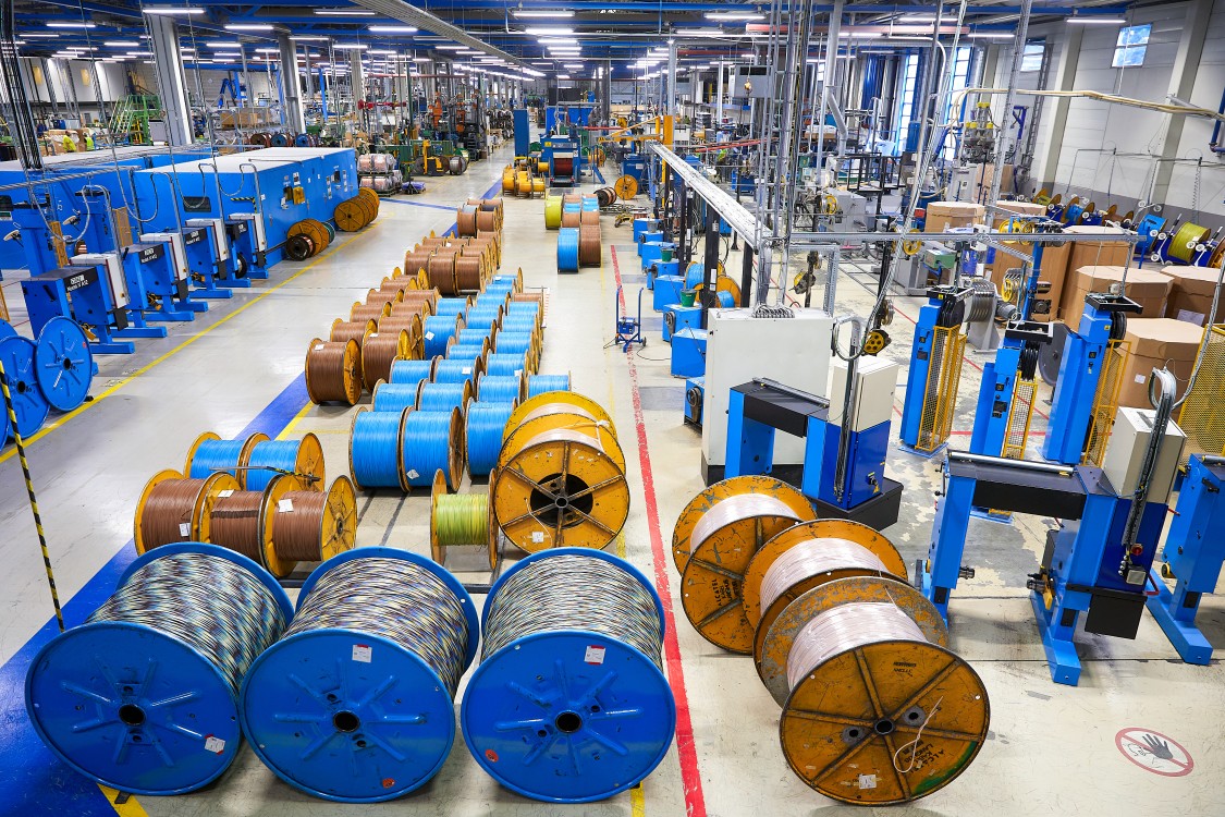 – innsiden av en kabelfabrikk på Langhus med mange kabelprodukter i blå farge på rekke og rad.