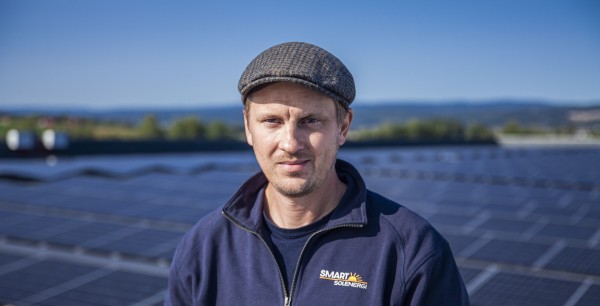 Portrett av Elling Ramstad fra Smart Solenergi på taket med solceller i bakgrunn.